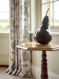 Curtains next to sculpture of a pear