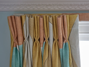 Triple pleat curtains hanging from a covered lath